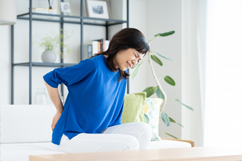 腰を抑える女性
